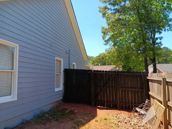 Pale blue-gray lap siding with white window trim, beside a dark-stained privacy fence