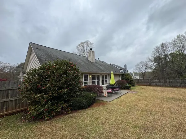 Single-story home with gray siding and white trim on an overcast day
