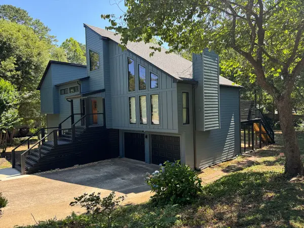 Blue-gray contemporary home with large windows and an exterior stair
