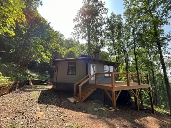 Small cabin with a new deck and steps built onto the front