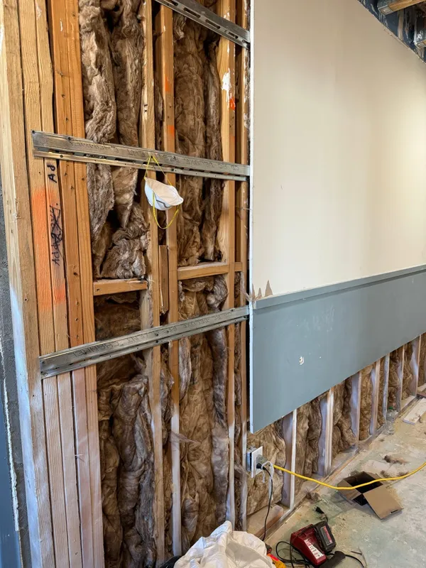 Wall part boarded over insulation, gray painted band below the line