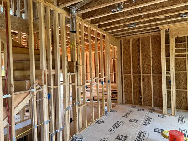 Interior stud framing over protected subfloor, wiring pulled and boxes set