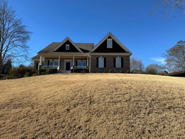 Brick and siding ranch with a covered porch, seen across the front slope