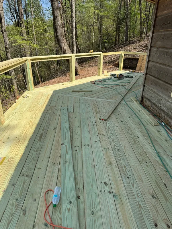Green treated deck part way through boarding, offcuts and lead still out
